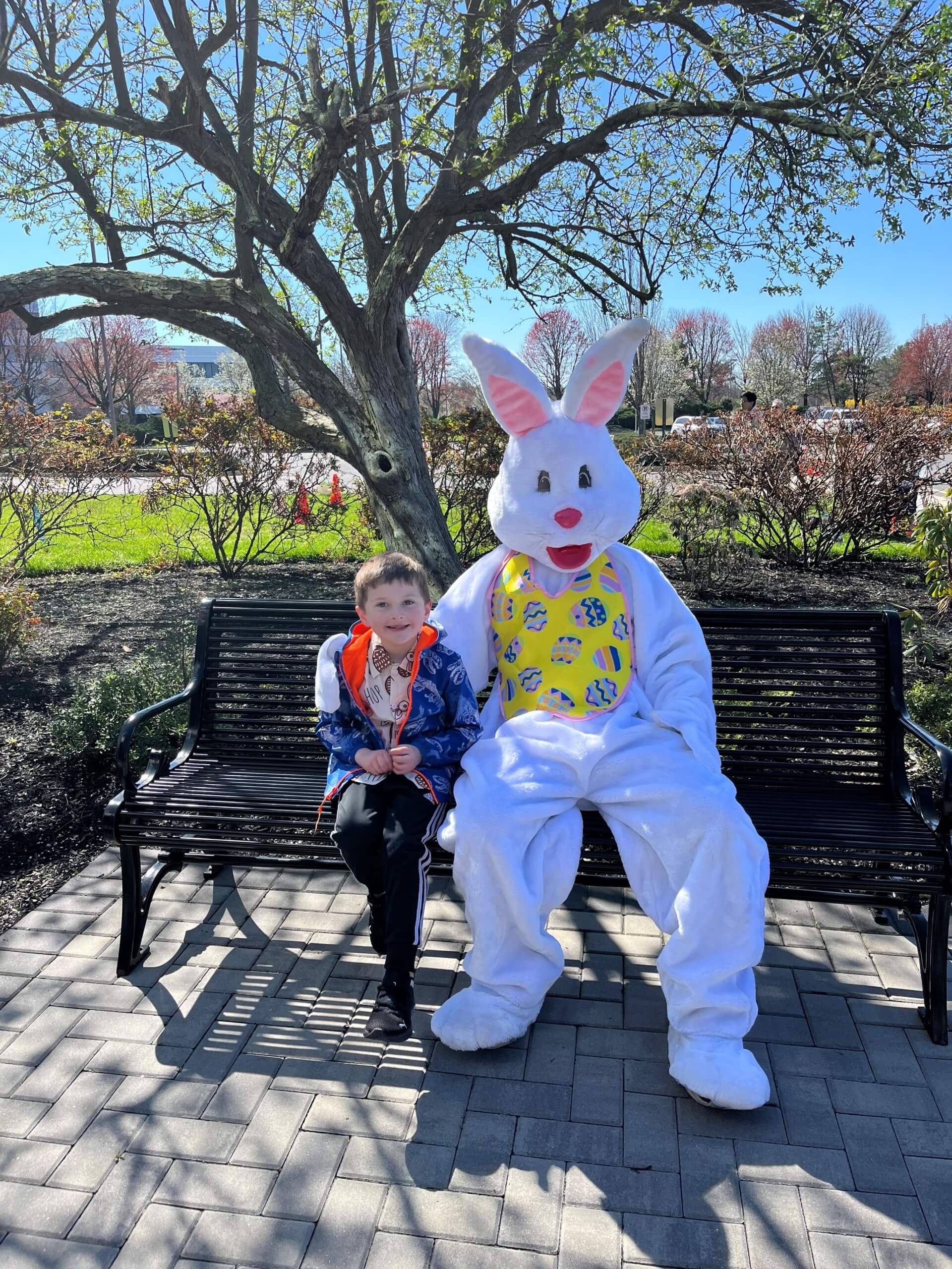 Boy smiling next to person wearing Easter bunny suit