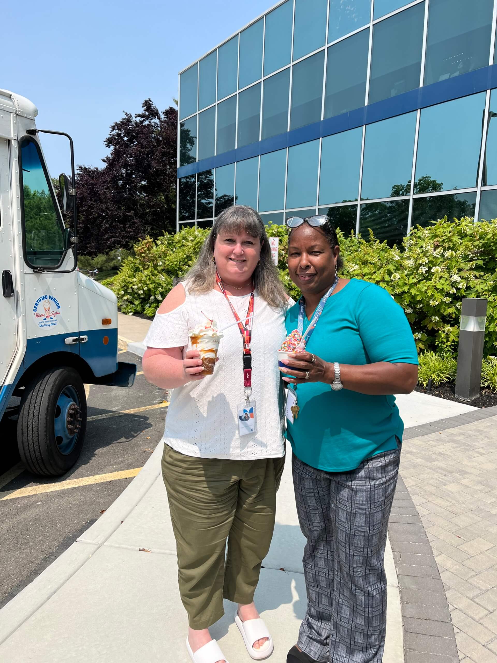 Two RetireeFirst employees holding ice cream next to ice cream truck