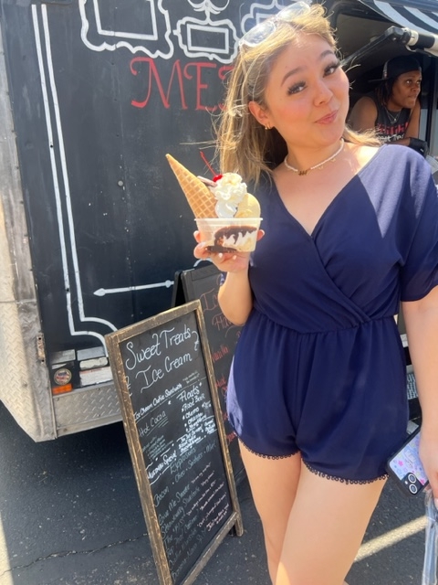 woman holding an ice cream sunday in front of an ice cream food truck