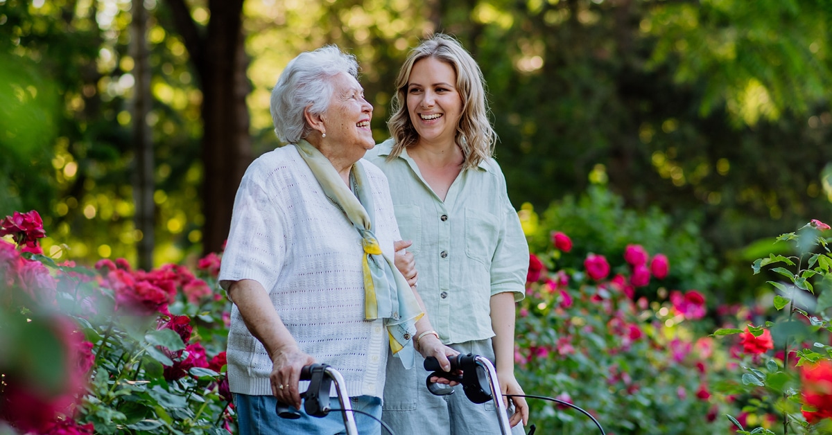 daughter walking with her grandmother outside in a garden