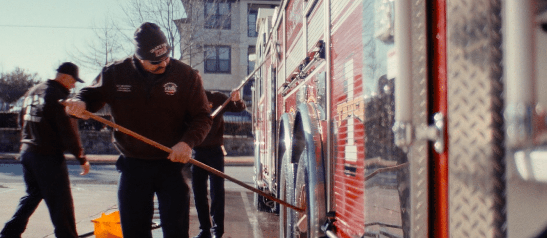 Firemen cleaning firetruck